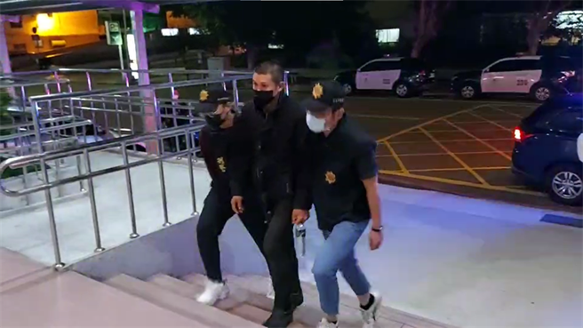 新竹市警方16日晚间将涉嫌泼尿的男子（中）带回局内，讯后将依公然侮辱、毁损罪嫌移送法办。（翻摄画面）