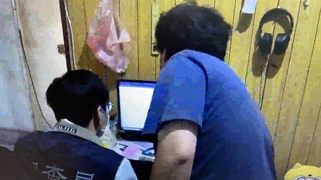 台南市调查处调查官检视张姓骇客的电脑。（读者提供／洪荣志台南传真）