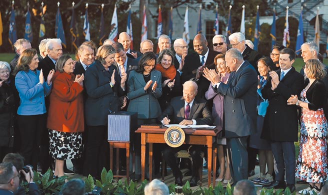 美国总统拜登15日签署1兆美元基础建设法案，民主、共和两党国会议员罕见同框见证。（中新社）