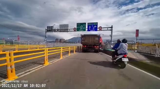 關渡大橋匝道縮減，機車騎士被砂石車擦撞，所幸未被捲入輪下。（圖／翻攝臉書社團爆料公社公開版）
