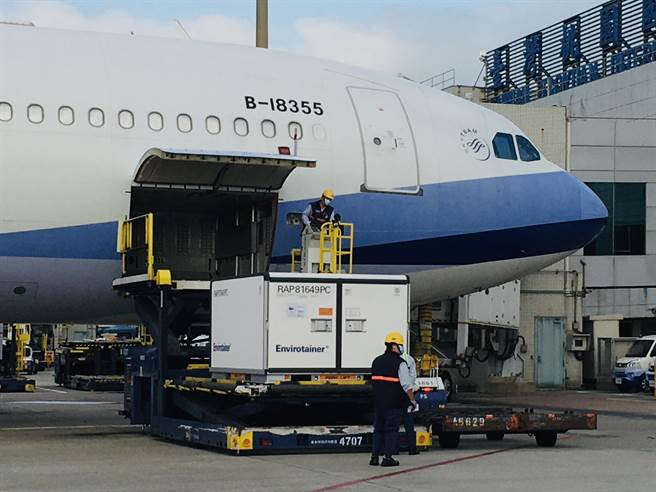 地勤人員將裝載疫苗的冷凍貨櫃卸下。（范揚光攝）