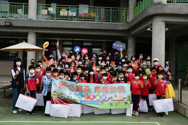 學童開心拿著幸福大禮包與元大志工合影。（元大金控提供／張亦惠嘉縣傳真）