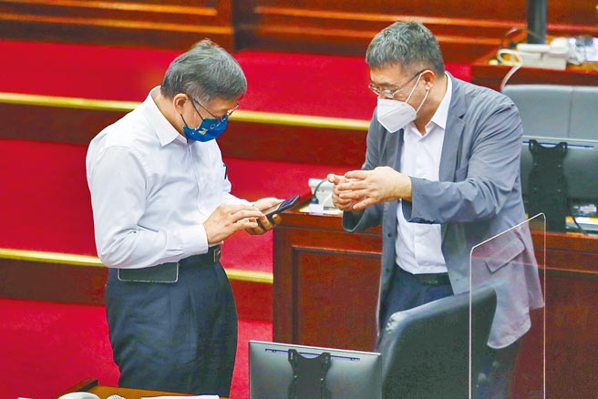 台北通17日傍晚5時起陸續傳出無法使用熊好券的狀況，先是卡在讀取畫面，接著顯示資訊錯誤，完全無法使用，一路當機到晚上9時多，令民眾抱怨連連，台北市長柯文哲（左）18日赴市議會備詢休息時間，幕僚向他報告相關事宜。（鄧博仁攝）