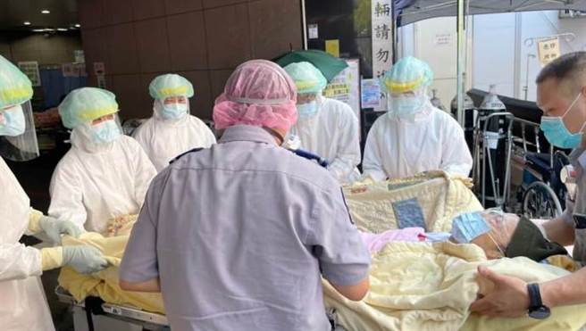 疫情警戒3級，一到急診室，民間救護車的救護員幫換急診病床。(圖/葉雅馨)
