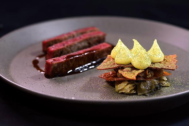 〈M67澳洲和牛肋眼／姜黄马铃薯／黄甜椒〉是以澳洲和牛肋眼煎烤至三分熟，配菜有三层，底层为炭烤发酵高丽菜、第二层是拌炒浓缩风味的黄甜椒、第三层为姜黄马铃薯泥与蒜苗粉。图／姚舜