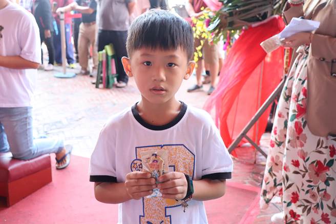 2021鲲鯓王平安盐祭21日举行博杯领福袋活动，来自麻豆的王小弟弟开心把福袋袋回家。(刘秀芬摄)