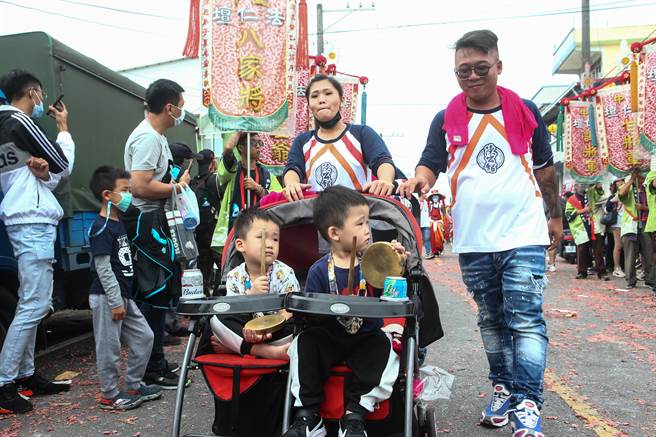 参加遶境的家长拖着小孩一起参与盛会。（邓博仁摄）