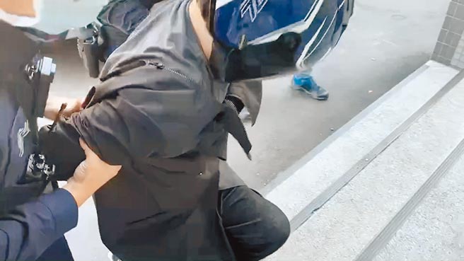 疫情指挥中心昨提醒，民眾规劝对方戴口罩时仍要注意自身安全。图为凶嫌蒋姓男子21日送往龟山派出所时，上楼梯数度腿软跪地，还要两旁员警一路边扛边扶才能进入警所。（蔡依珍摄）