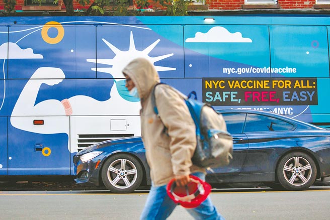 歐洲新冠疫情快速蔓延，世界衛生組織（WHO）20日警告，若未能採取緊急因應措施，明年3月前，歐洲死於新冠肺炎的人數可能再增加50萬。圖為一名行人走過一輛新冠疫苗接種車。（新華社）