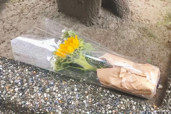桃園龜山超商店員遭刺死，有民眾22日冒雨到事發超商外獻花悼念。（蔡依珍攝）