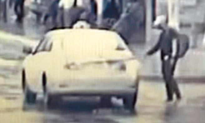 新北市新店咖啡商人命案，凶嫌先在龙山公园欲将衣物送给民眾遭拒后，随即在路边招下一台计程车潜逃。（警方监视器）