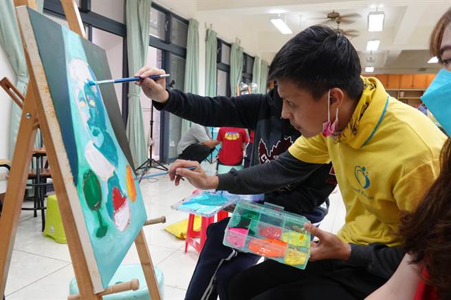 国立台东女中学生25日带领台东牧心智能发展中心憨儿在校园写生。（蔡旻妤摄）