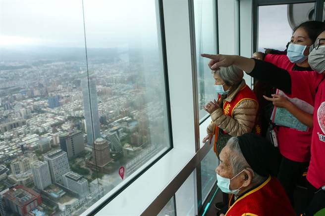 多位长者在感恩节当天受到华山基金会邀请参访101大楼观景台，望着远方找寻自己住在哪一区。（邓博仁摄）