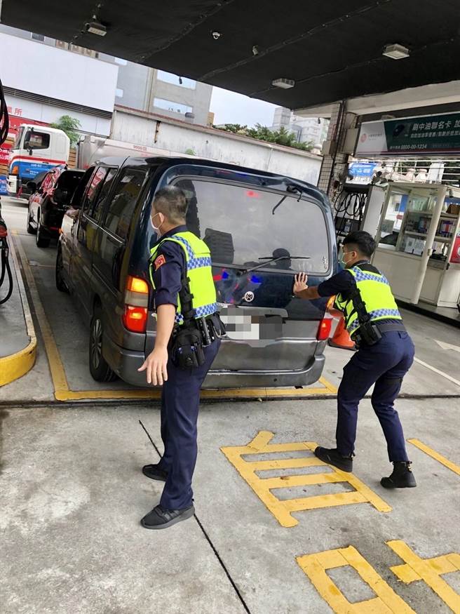 两名员警合力将箱型货车推上加油站的斜坡，顺利进入加油岛进行加油。（翻摄照片／林郁平台北传真）