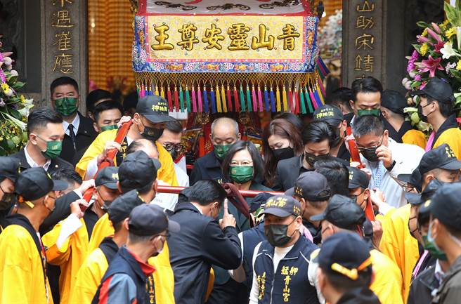 蔡英文总统（中）26日出席「艋舺青山王祭起驾仪式」，在眾人簇拥下扶着銮轿缓缓走出庙门。（范扬光摄）