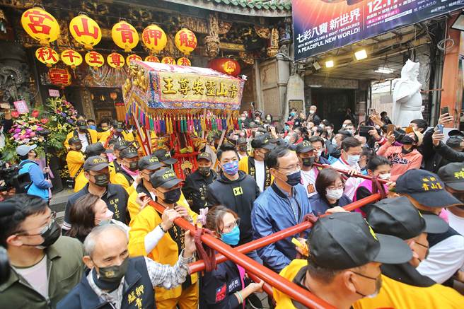 台北市万华区青山宫第二天的遶境及夜间暗访，国民党主席朱立伦、立委蒋万安特地前来共襄盛举，在起轿时一起扛轿。（杜宜谙摄）