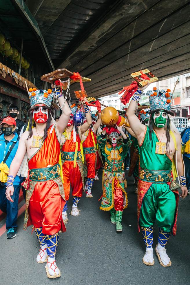 青山宫八将由八人扮演，四人扮青面的锁将军，另四人为红面的枷将军，手持手铐、火籤、鲤鱼扣、虎头牌等刑具，站在红绿枷锁将军队伍中间的，则是由稚童装扮的引路童子，拿着收伏鬼魂的葫芦，相传为白鹤化身，指引前路。(郭吉铨摄)
