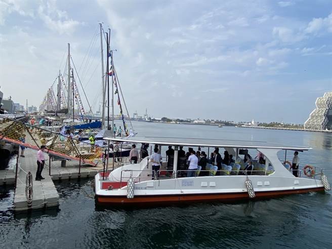 智駕船搭載中央和市府官員成功安全抵達岸邊，後方為參加帆船比賽的各式帆船。（石秀華攝）