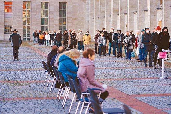 歐洲約每兩天通報100萬新冠肺炎確診病例，已有多國宣布加強疫情防控措施。圖為德國柏林一處疫苗接種中心，人們排隊接種疫苗。（美聯社）