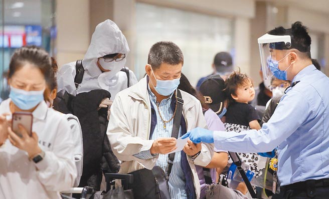 由于新型变异株B.1.1.529传播力强，中央流行疫情指挥中心26日宣布，自11月29日0时（航机抵台时间）起，将南非、波札那、纳米比亚、赖索托、史瓦帝尼及辛巴威等6国列为「重点高风险国家」；图为桃园机场防疫人员协助旅客上网登录入境健康资料。（范扬光摄）
