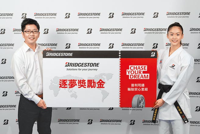 空手道选手「小清新」文姿云（右）今年在东京奥运舞台上展现韧性，勇夺台湾奥运史上首面空手道奖牌。为了庆祝文姿云拿下亮眼成绩，台湾普利司通经营企划部资深经理铃木俊辅（左）颁发逐梦奖励金。（普利司通提供）