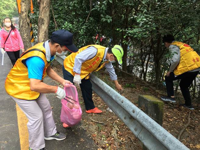 台電高雄區處舉辦南壽山淨山活動，處長李衍新(左三)和居民沿途撿拾垃圾。（台電提供）