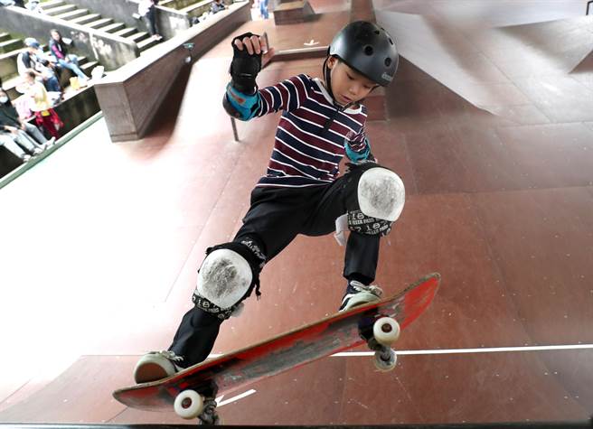 滑板競速障礙賽項目，參賽的國小組選手著完整保護的裝備登場，在計時制比賽中滑上高台的頂點後凌空翻身坐360度的迴轉下坡，追求最高的速度。（鄭任南攝）