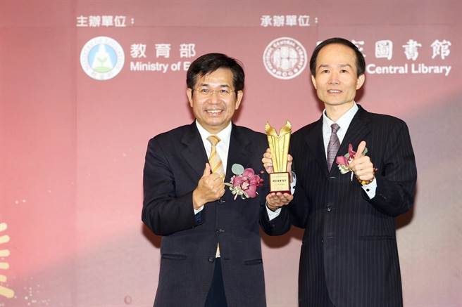 第一屆教育部圖書館事業貢獻獎頒獎典禮，國資圖館長劉仲成（右）獲教育部長潘文忠（左）頒發「標竿圖書館獎」。（國資圖提供）