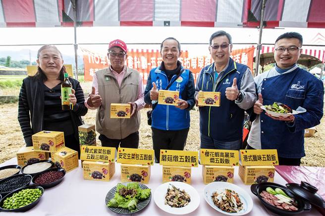 县府农业处长范万钊（中）推荐北埔农会以在地食材制成的「五行杂粮饭」，总干事庄烘冈（右二）说，今年增加一味「苦茶油」。（罗浚滨摄）