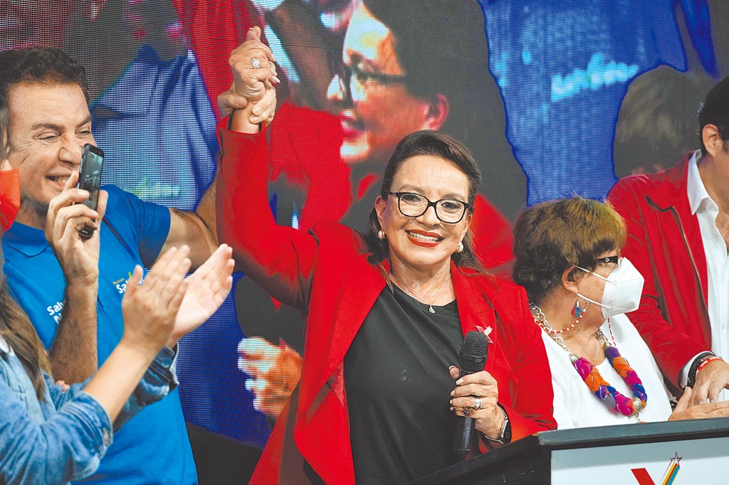 宏都拉斯28日舉行大選，左翼自由重建黨候選人卡斯楚（中）被她的競選夥伴納斯拉亞舉起了手，自行宣布勝選。（美聯社）