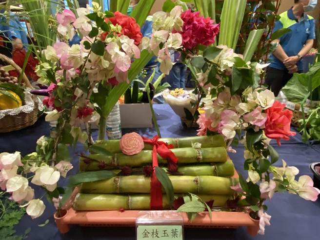 新移民陈泳伶用一节节甘蔗搭配自家种的玫瑰花、九重葛搭配成「金枝玉叶」作品。（廖素慧摄）