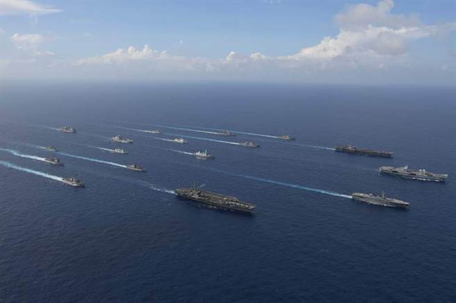 美國發布最新全球軍力部署評估，報告著重印太地區軍力部署的調整，形容中國對美國造成「步步緊逼的挑戰」，在與台灣軍事合作部份則「無可奉告」。圖為美英日3國航母聯合打擊群遊弋南海。（圖／美國海軍）