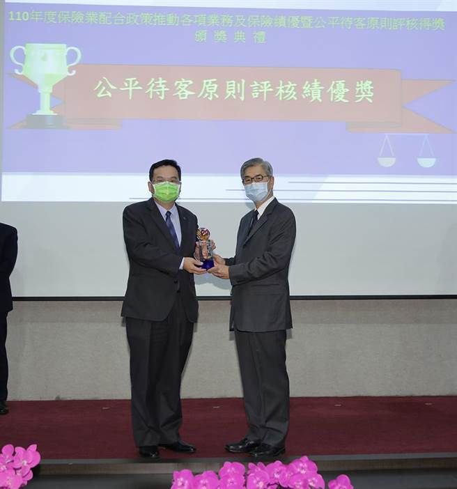 （金管会主委黄天牧(右)颁发产险的公平待客评比成绩，国泰产险荣获绩优肯定，由总经理陈万祥(左)亲自领奖。照／国泰提供）
