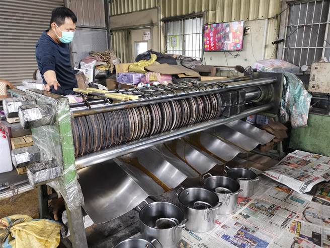 胡麻经高温炒过后需用机器吹凉、研磨压破，再放进木桶用蒸气炊热，倒出包成油饼，以油压机缓慢施加压力把油榨出。（刘秀芬摄）