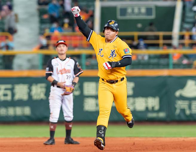 中信兄弟陈子豪（右）在7局上轰出打破僵局的3分红不让，跑垒时英雄般的高举右手。（盖艾传媒提供）