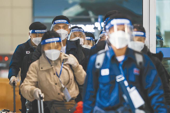 在疫情籠罩下，戴著口罩和防護面罩的旅客11月30日抵達韓國仁川國際機場。（美聯社）