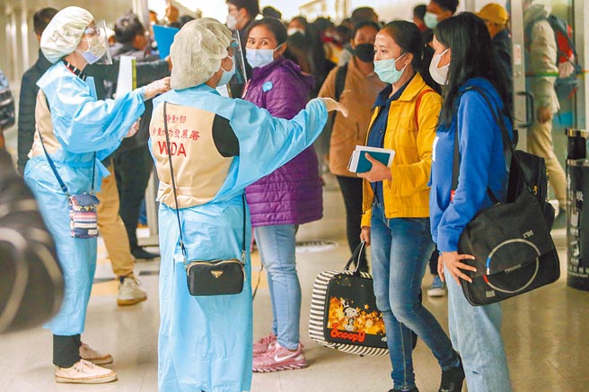 我国重启印尼移工入境，移工透过积分制排序入境顺序，第一波取得集中检疫所床位的有96人。图为日前搭乘华航CI762的4名印尼移工，在劳动部委外人员的引导下，准备入境。（本报资料照片）