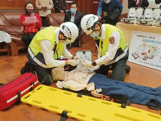 在捐贈儀式上，消防局人員現場示範如何操作心電圖機搶救病患。（胡健森攝）