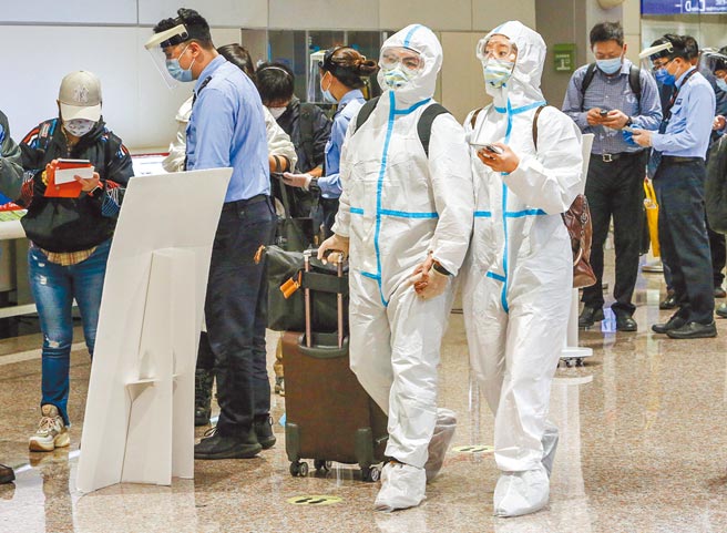新冠肺炎变异株Omicron疫情拉警报，新北市长侯友宜连续多次呼吁春节7+7检疫方案该重新思考，多名专家也呼吁要回归14+0。图为桃园机场部分入境旅客穿着全副武装。（陈麒全摄）