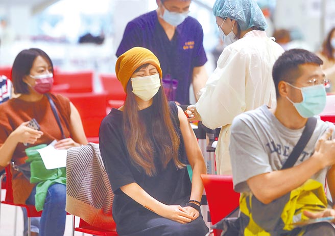 目前國內還有超過900萬劑疫苗可供接種，指揮官陳時中呼籲大家盡速接種。圖為民眾1日到台北市花博接種站施打BNT疫苗，注射時面露疼痛表情。（劉宗龍攝）