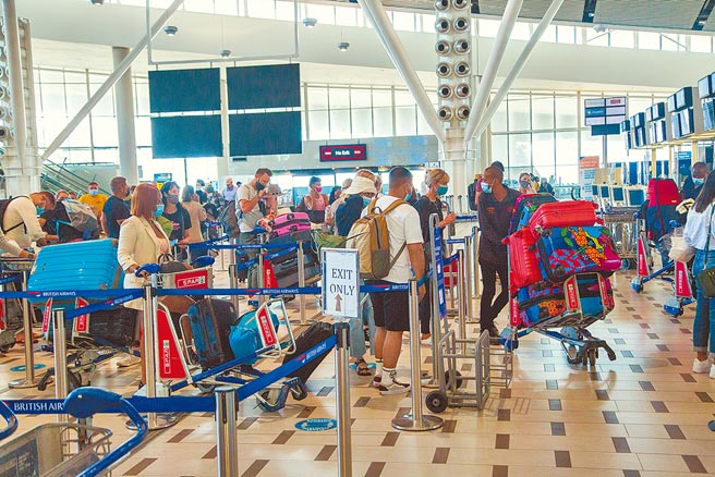 南非变异株Omicron来势汹汹，图为旅客在南非开普敦国际机场办理登机手续。（新华社）