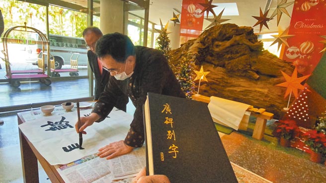 书法家罗浩铨在饭店现场笔墨挥毫呈现碑别字风采。（蔡旻妤摄）