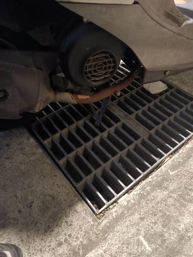 刘女体型娇小，其机车中柱不偏不倚卡进水沟盖，牵也牵不动。（台中市警三分局提供／张妍溱台中传真）