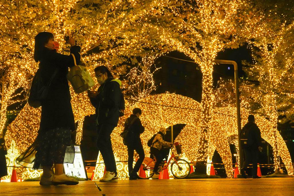 台北101大樓廣場裝設漂亮的LED耶誕燈飾，吸引許多上班族駐足拍照。（黃子明攝）