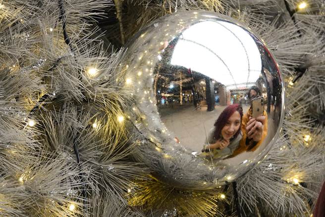 台北市信義區一家百貨公司設置大型耶誕樹，大型鏡面球飾成為民眾取景目標。（黃子明攝）