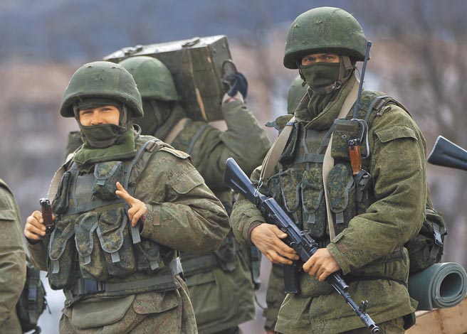 俄羅斯曾於2014年入侵烏克蘭東部和吞併克里米亞，圖為當年克里米亞的親俄部隊接近一座烏軍基地時，一名士兵比出象徵勝利的手勢。（美聯社）