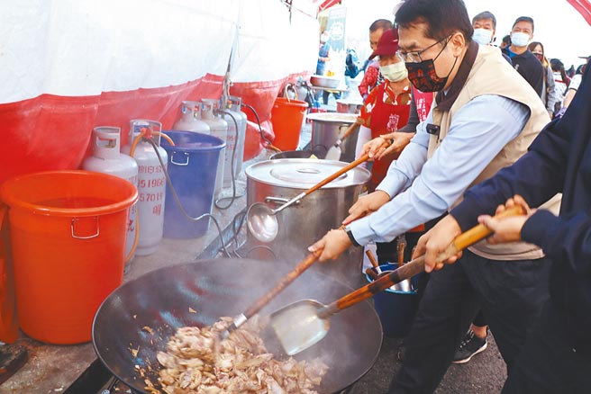 台南市长黄伟哲（右）参加西港胡麻节活动，亲自炒麻油鸡。（刘秀芬摄）