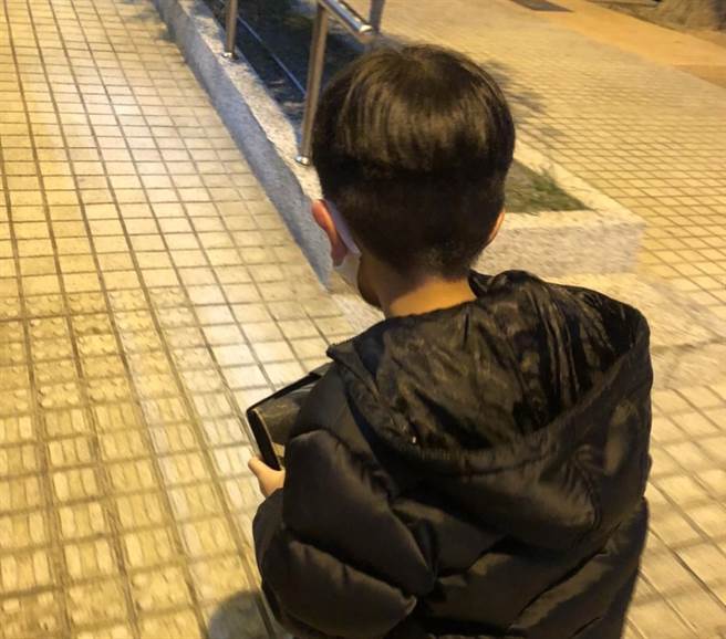 小男孩手中紧握着一只皮夹，在母亲的陪同下怯生生地走到值班台。(警方提供)