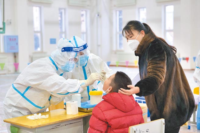 12月5日，一名學生在家長的陪同下進行核酸採樣。當日，內蒙古自治區呼倫貝爾牙克石市圖里河地區對當地重點人群展開核酸採樣檢測工作。（中新社）