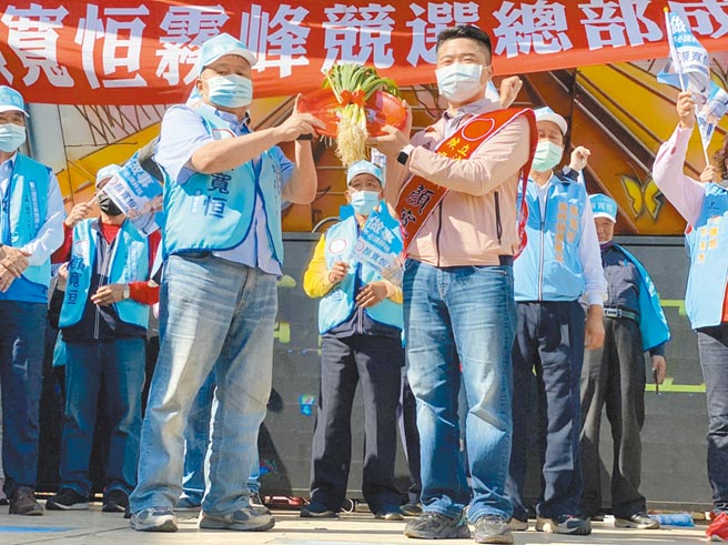 台中市第二选区立委补选，国民党参选人顏宽恒（右）5日成立雾峰竞选总部，大甲镇澜宫董事长顏清标（左）为其子上送上象徵「冻蒜」的「青蒜」。（读者提供／张妍溱台中传真）